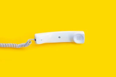 Sarı arka planda sabit telefon ahizesi.