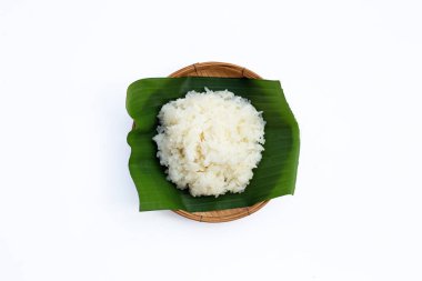 Muz yaprağına yapış yapış pirinç, beyaz arka planda bambu sepeti..