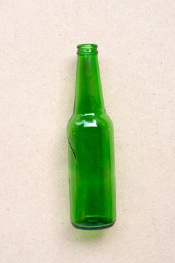 Green glass bottle on brown background.