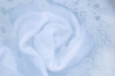Top view of towel soak in powder detergent water dissolution. Laundry concept