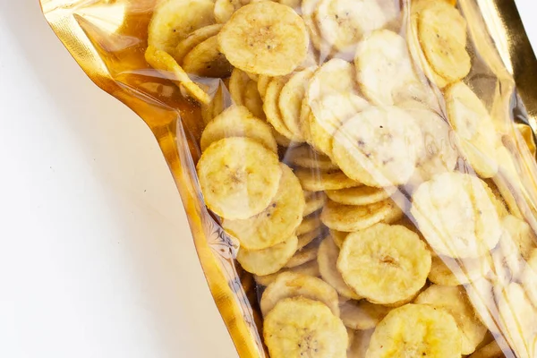 Banana slice chips in package bag on white background.