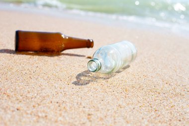 Cam şişeler sahilde
