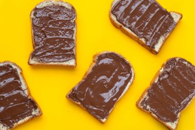 Sarı arka planda çikolata fındıklı ekmek.