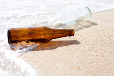 Cam şişeler sahilde