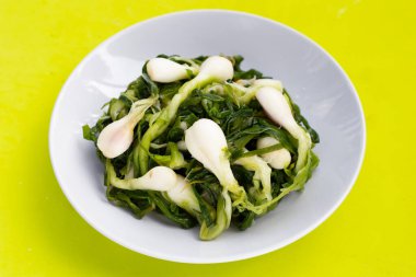 Beyaz tabakta turşulu taze soğan.