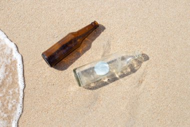 Cam şişeler sahilde