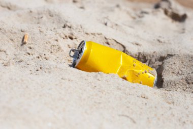 Yellow can waste on the beach