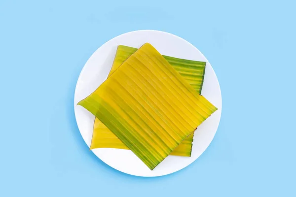 Banana leaves on plate on blue background.
