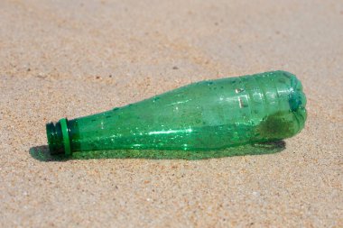 Green plastic bottle on the beach