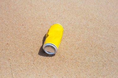 Yellow can waste on the beach