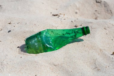 Green plastic bottle on the beach