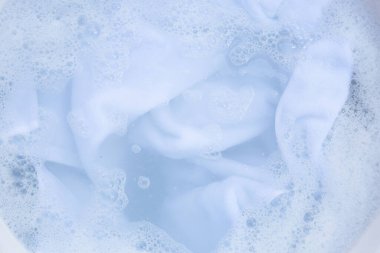 Top view of towel soak in powder detergent water dissolution. Laundry concept