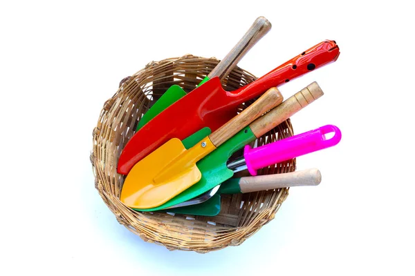 Garden shovel with fork in bamboo basket on white background. Garden tools