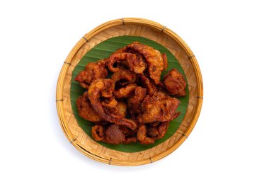 Chispy fried chicken skin in bamboo weave plate on white background.