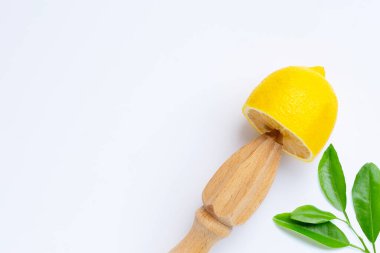 Beyaz arka planda ahşap sıkacağı olan taze limon.