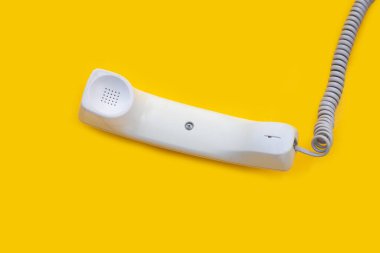 Sarı arka planda sabit telefon ahizesi.