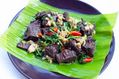 Kızarmış tavuk kanı küpleri ve fesleğenle doğranmış domuz eti.