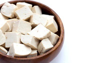 White tofu in wooden bowl on white background.