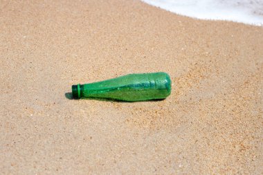 Green plastic bottle on the beach