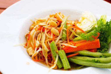 Beyaz tabakta baharatlı papaya salatası.