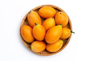 Beyaz arka planda bambu dokuma tabağında Marian erik meyvesi