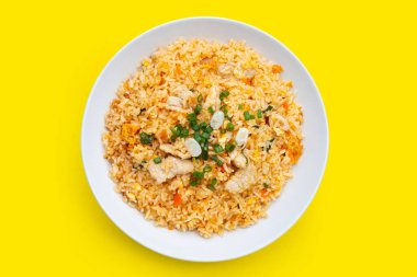 Sarı arka planda beyaz tabakta kızarmış pirinç. Üst görünüm