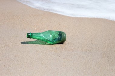 Green plastic bottle on the beach