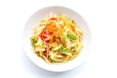 Beyaz arka planda baharatlı papaya salatası tabağı.