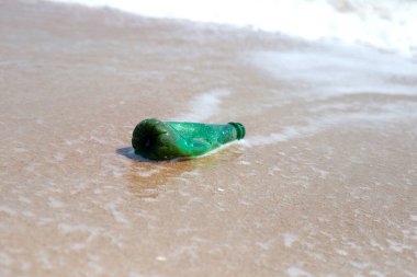 Green plastic bottle on the beach