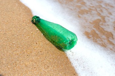 Green plastic bottle on the beach