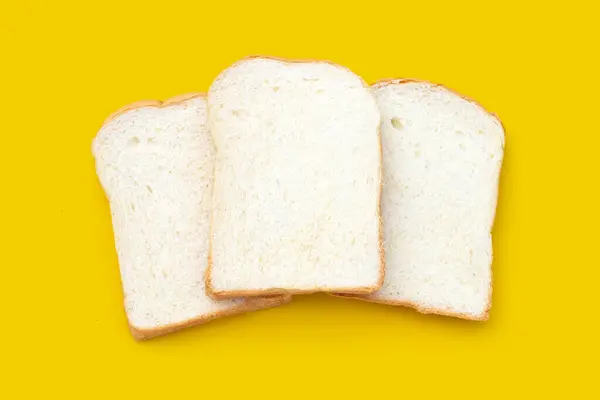 黄色の背景にスライスしたパン — ストック写真