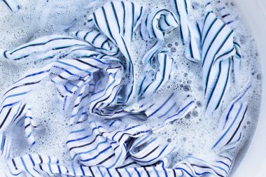 Top view of formal shirts soak in powder detergent water dissolution. Laundry concept