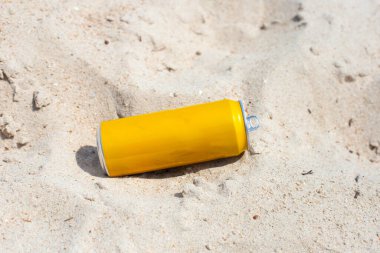 Yellow can waste on the beach