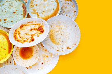 Sarı arka planda kirli tabaklar. Üst görünüm