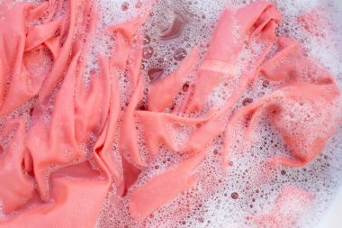 Top view of formal shirts soak in powder detergent water dissolution. Laundry concept