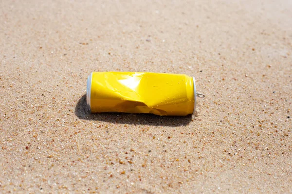 Yellow can waste on the beach