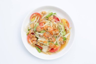 Beyaz arka planda baharatlı papaya salatası tabağı.