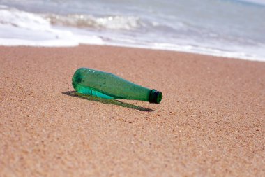 Green plastic bottle on the beach