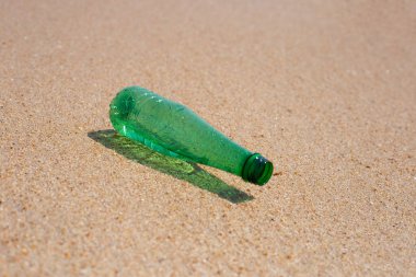 Green plastic bottle on the beach