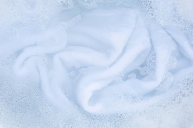 Top view of towel soak in powder detergent water dissolution. Laundry concept