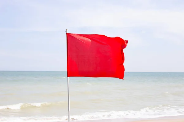 stock image A red flag. Warning sign on the beach