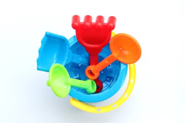 Plastik oyuncaklar, kovadaki kürekler beyaz arka planda kum için. Yaz arkaplanı kavramı