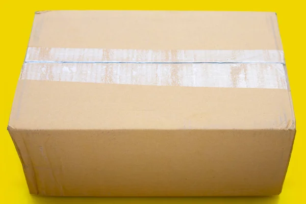Картонная Коробка Отверстием Желтом Фоне — стоковое фото