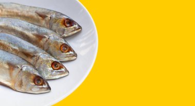 Salted fish on yellow background.