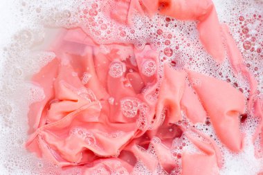 Top view of formal shirts soak in powder detergent water dissolution. Laundry concept