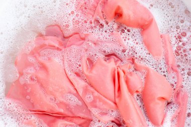 Top view of formal shirts soak in powder detergent water dissolution. Laundry concept