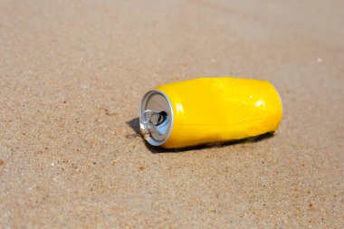 Yellow can waste on the beach