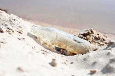 Cam şişeler sahilde