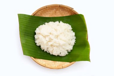 Muz yaprağına yapış yapış pirinç beyaz arka planda bambu dokuma tabağıyla. 