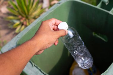 Boş plastik şişeyi geri dönüşüm çöpüne atmak.